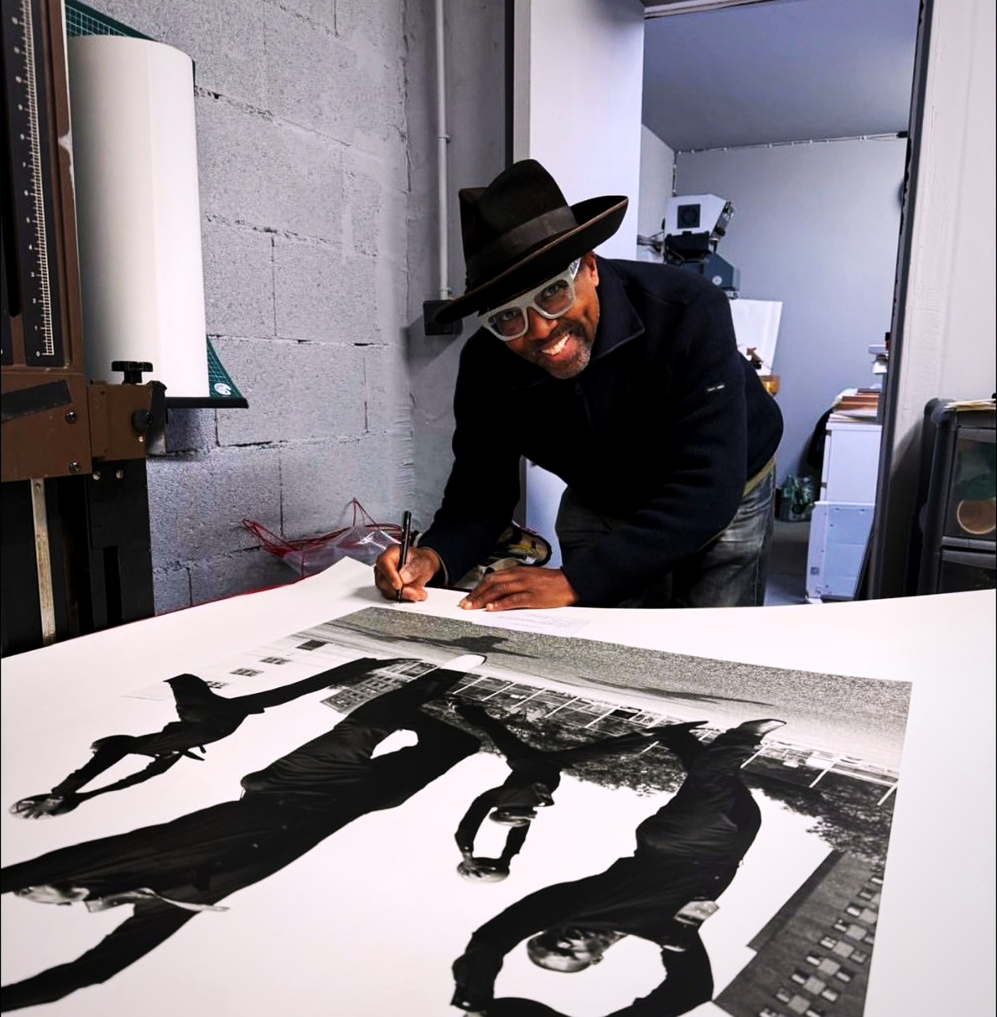 Koto Bolofo signing the Basketball Ballet 1 print in his studio