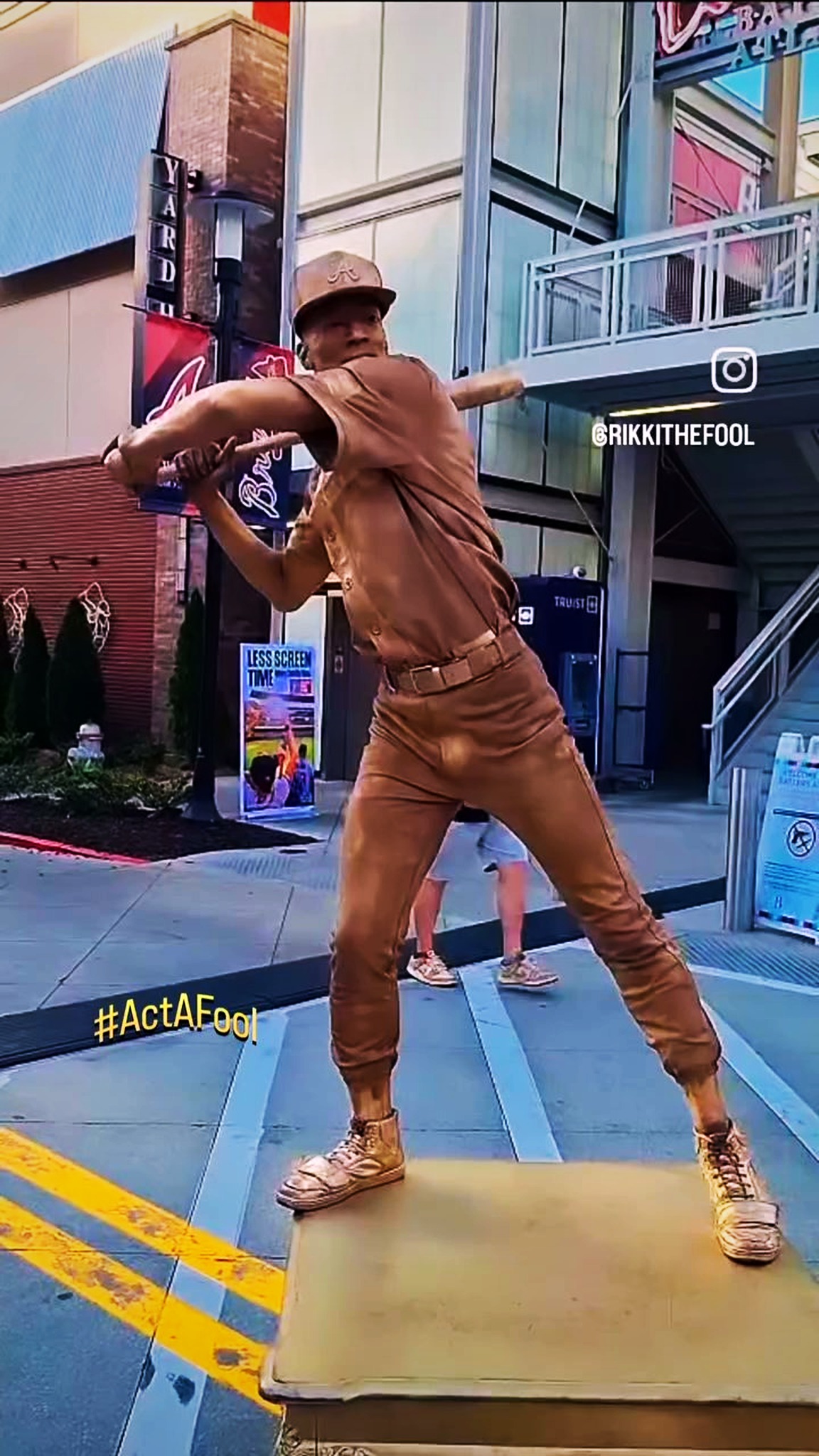 RikkiTheFool as the gold-painted living statue in a baseball pose at The Battery